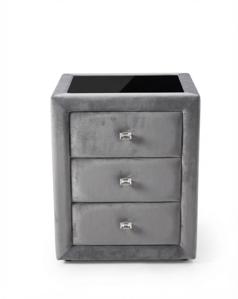A small gray three-drawer nightstand or side table with a glossy black top surface and small silver drawer pulls.